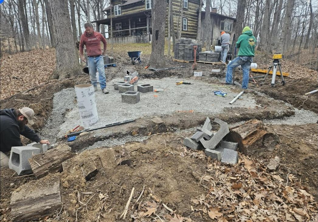 The crew setting the base for a hardscape at a log home